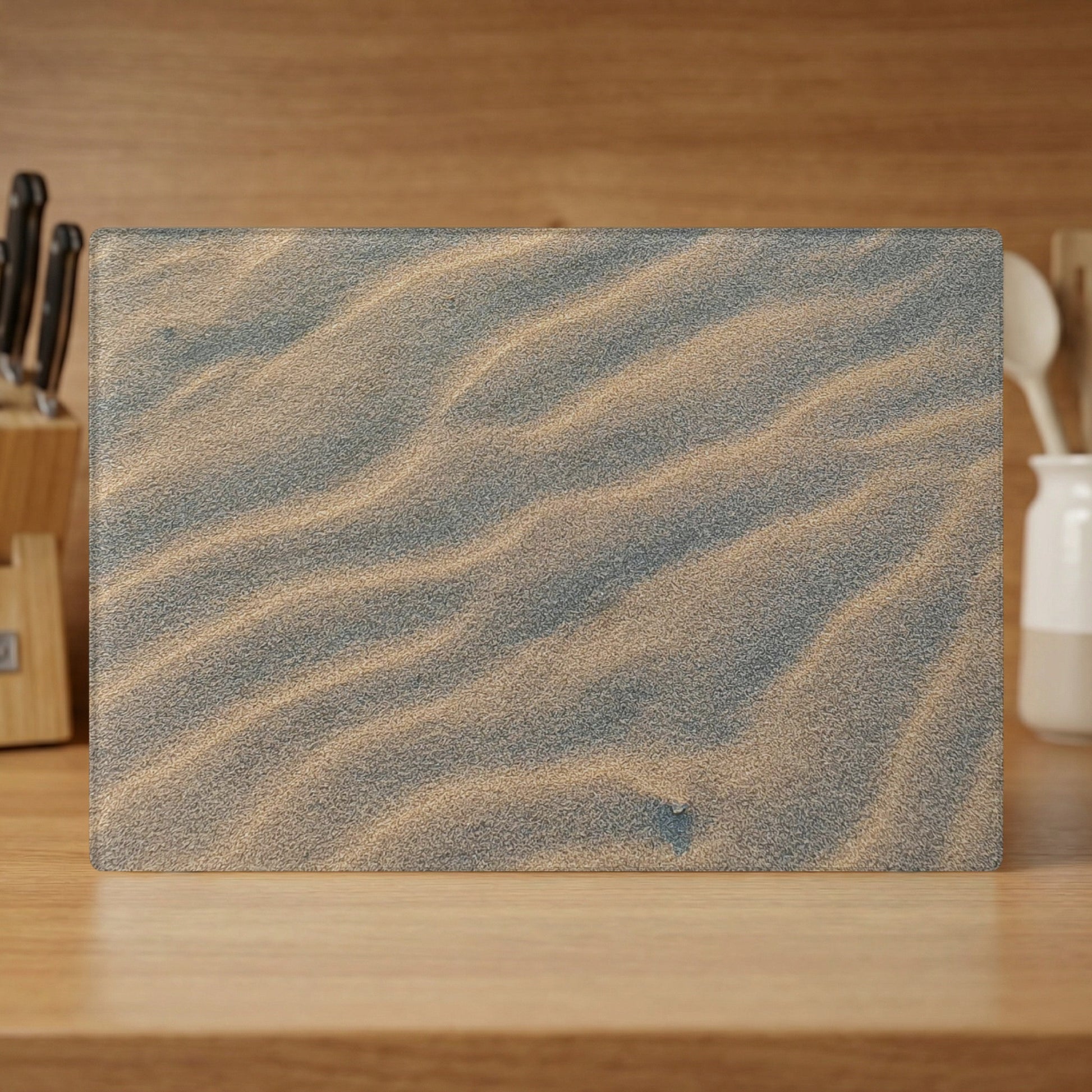 Sand dunes texture on a rectangular glass cutting board.