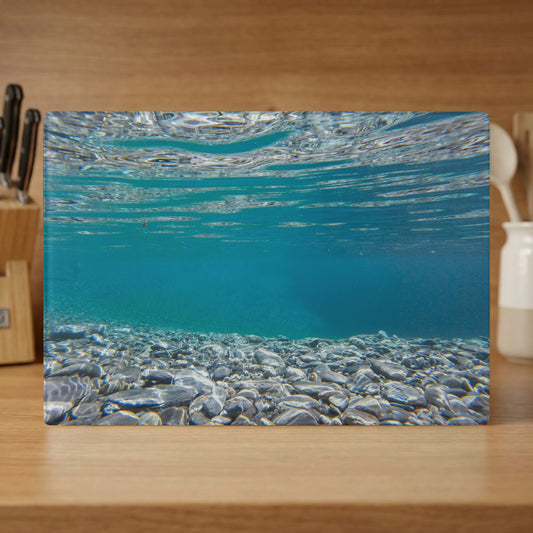Underwater view of clear turquoise water over a rocky seabed.